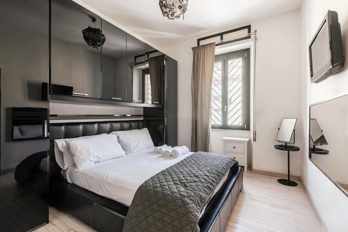 Master bedroom with king-size bed in our Rome apartment near San Giovanni